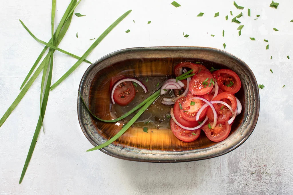 Salade de tomate et oignon dans un bol ovale Le bol ovale Comporta L Ensemble de 4