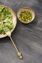 Salade avec pois verts et ananas dans une fourchette sur set de bols en céramique beige dégradé
