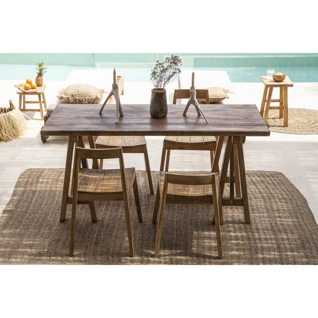 Table à manger en bois foncé avec quatre chaises sur un tapis texturé près du Bougeoir blanc en forme de branche organique
