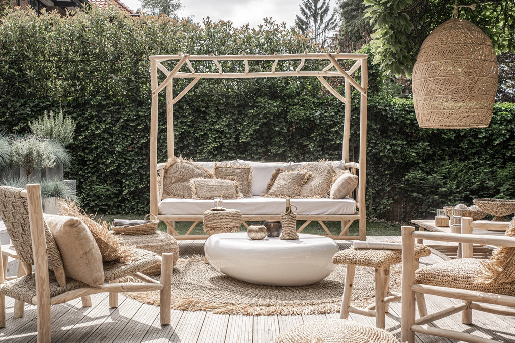 Lampe pendentif en osier beige tissé suspendue à une pergola en bois