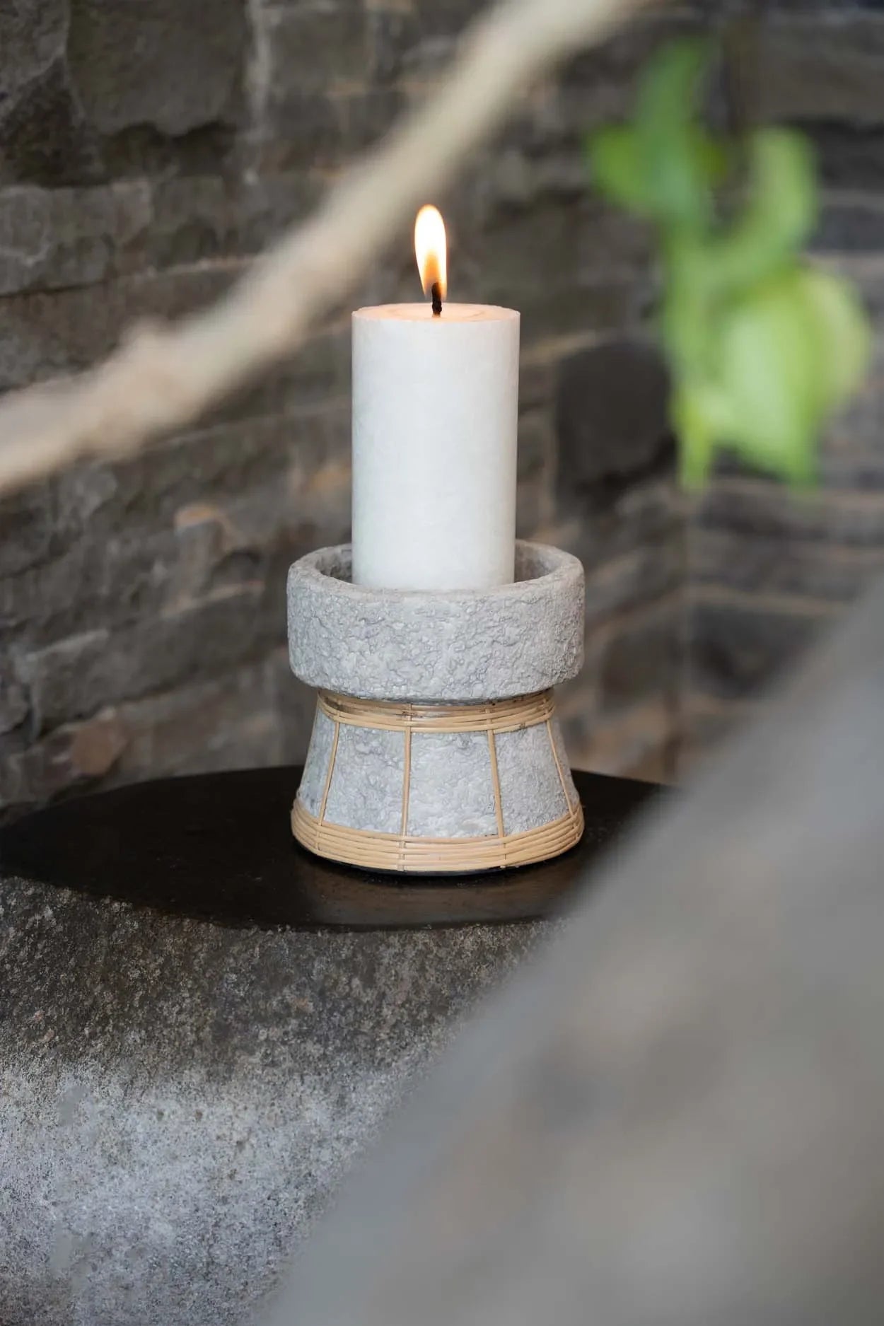 Bougeoir en terre cuite et rotin gris béton 12 cm avec bougie blanche en feu
