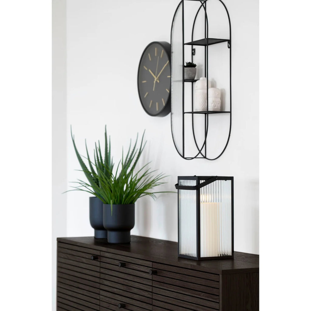 Lanterne métal noir avec panneaux verre verticaux et bougie blanche allumée