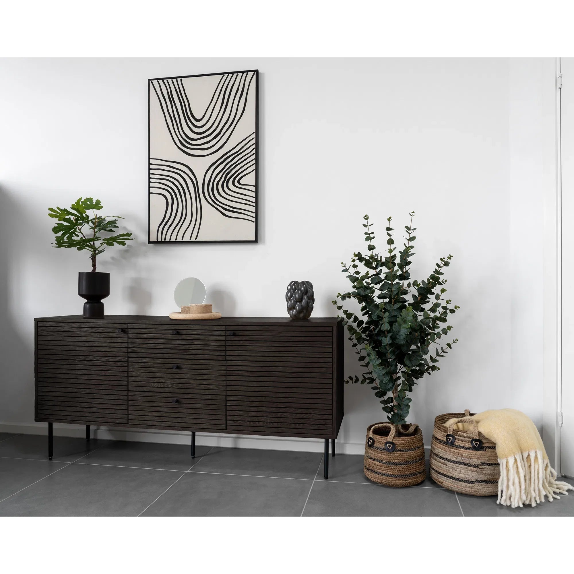 Console en bois noir avec œuvres d’art et plantes pour décoration intérieure élégante