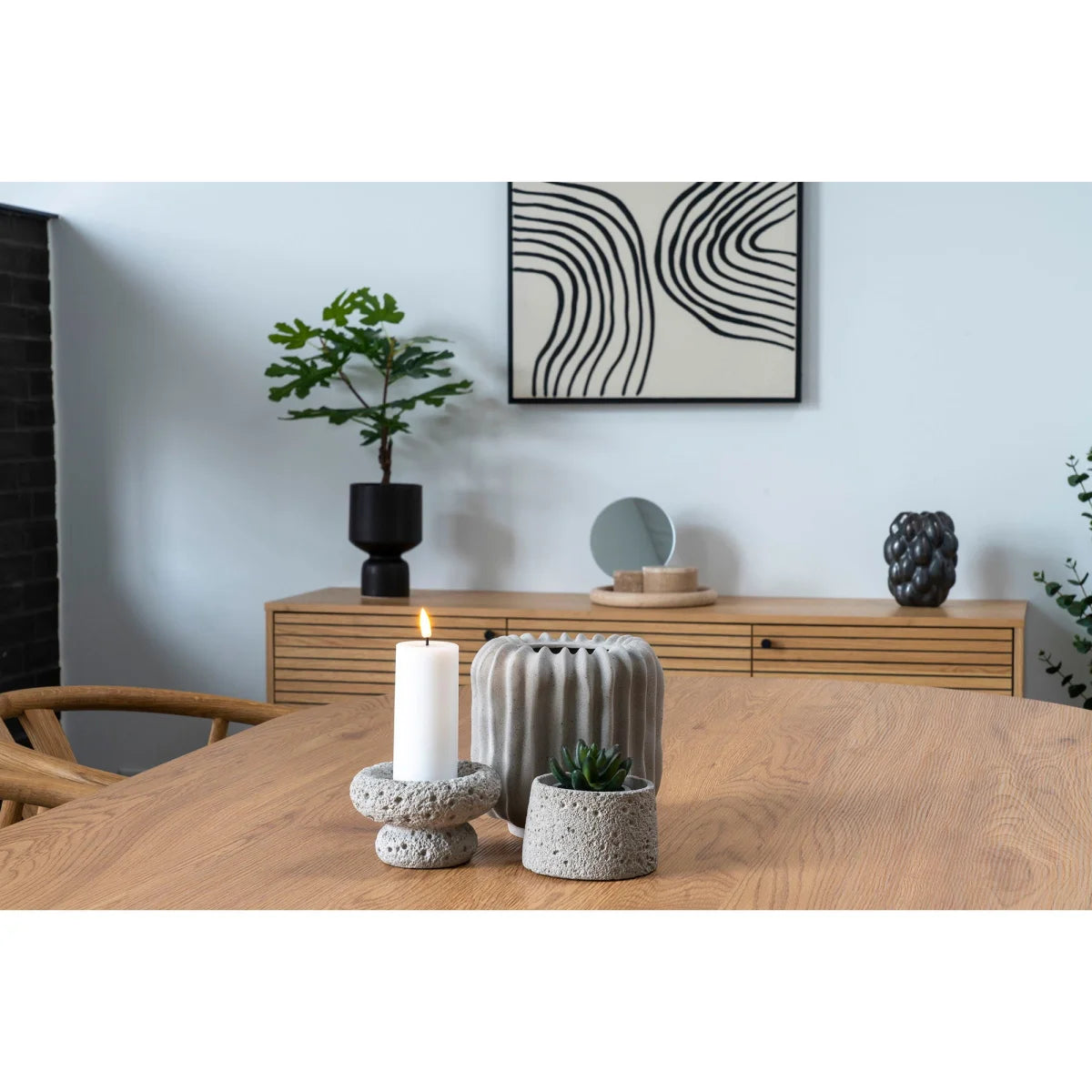 Porte-bougie en béton gris texturé avec bougie blanche allumée, H23 cm