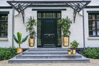 Entrée élégante de maison avec plantes dans le cache-pot en laiton sur support M
