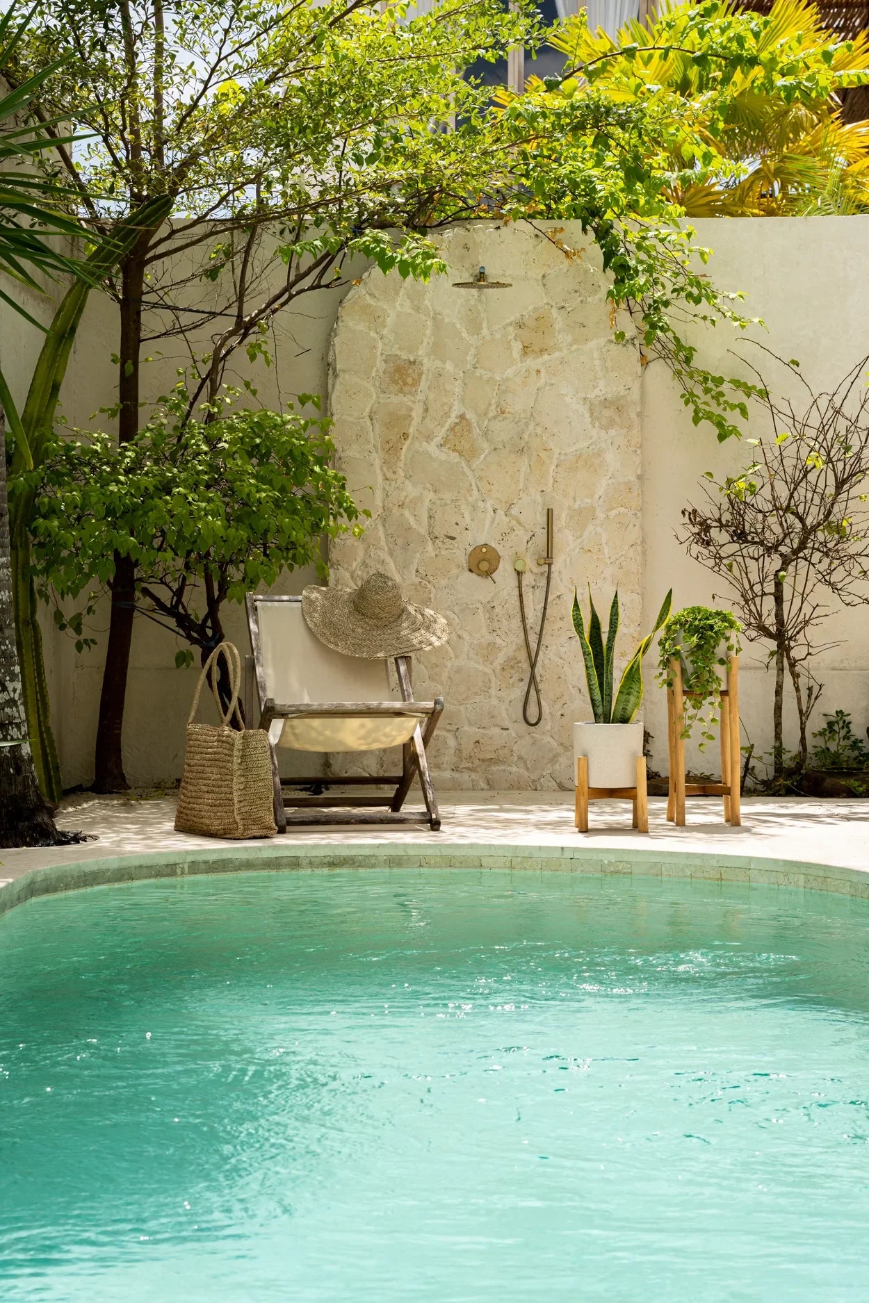 Aire de douche extérieure au bord de la piscine avec cache-pot en terre cuite et teck