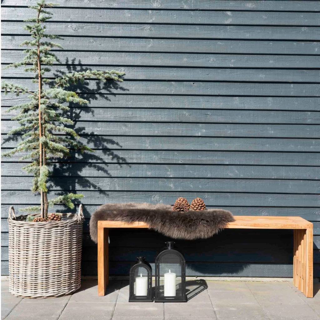 Banc en bois rustique avec couverture en fourrure et pommes de pin