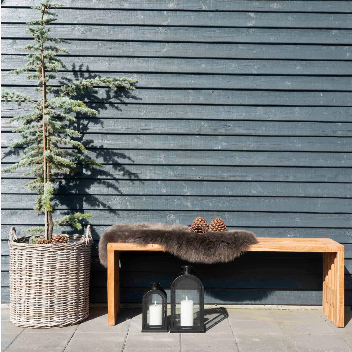 Banc en bois rustique avec couverture en fourrure et pommes de pin