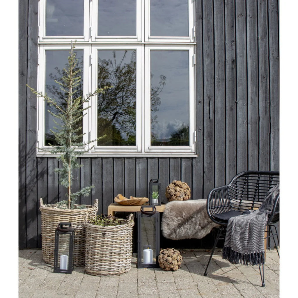 Cache-pots ronds en rotin Kubu avec anses et doublure plastique dans un espace extérieur cosy