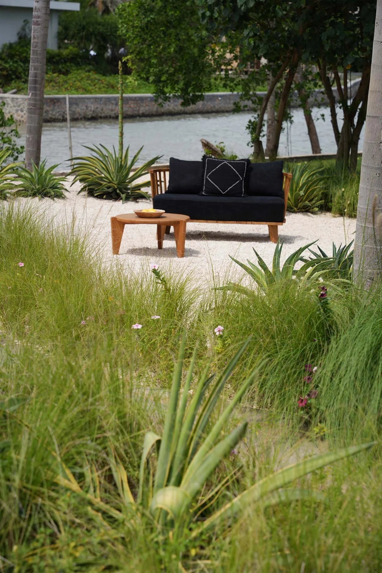 Canapé en teck recyclé avec coussins noirs pour extérieur élégante et confortable