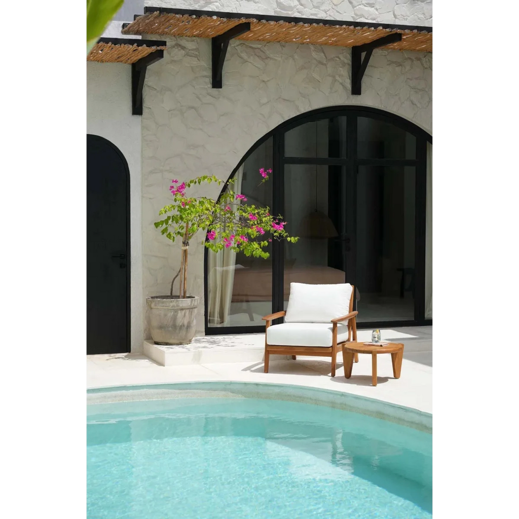 Canapé une place en teck recyclé avec coussins blancs près de la piscine extérieure