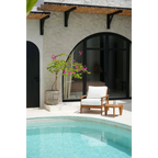 Canapé une place en teck recyclé avec coussins blancs près de la piscine extérieure