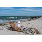 Chaise longue asymétrique en teck sur une plage pour une relaxation élégante
