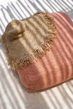 Poufs en tissu beige tressé frangé, près de la piscine