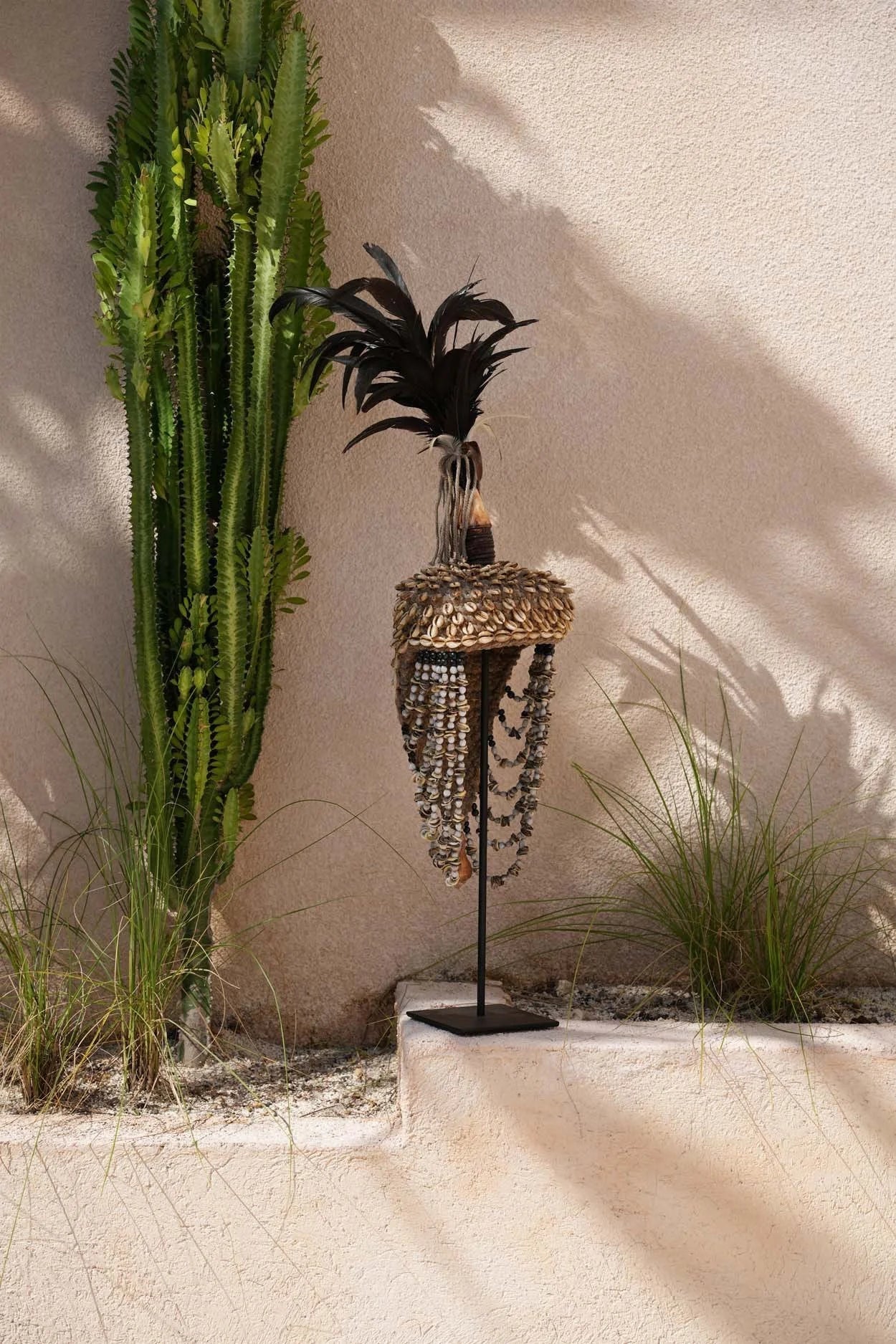 Headdress en plumes et coquillages sur socle noir naturel pour décoration artisanale