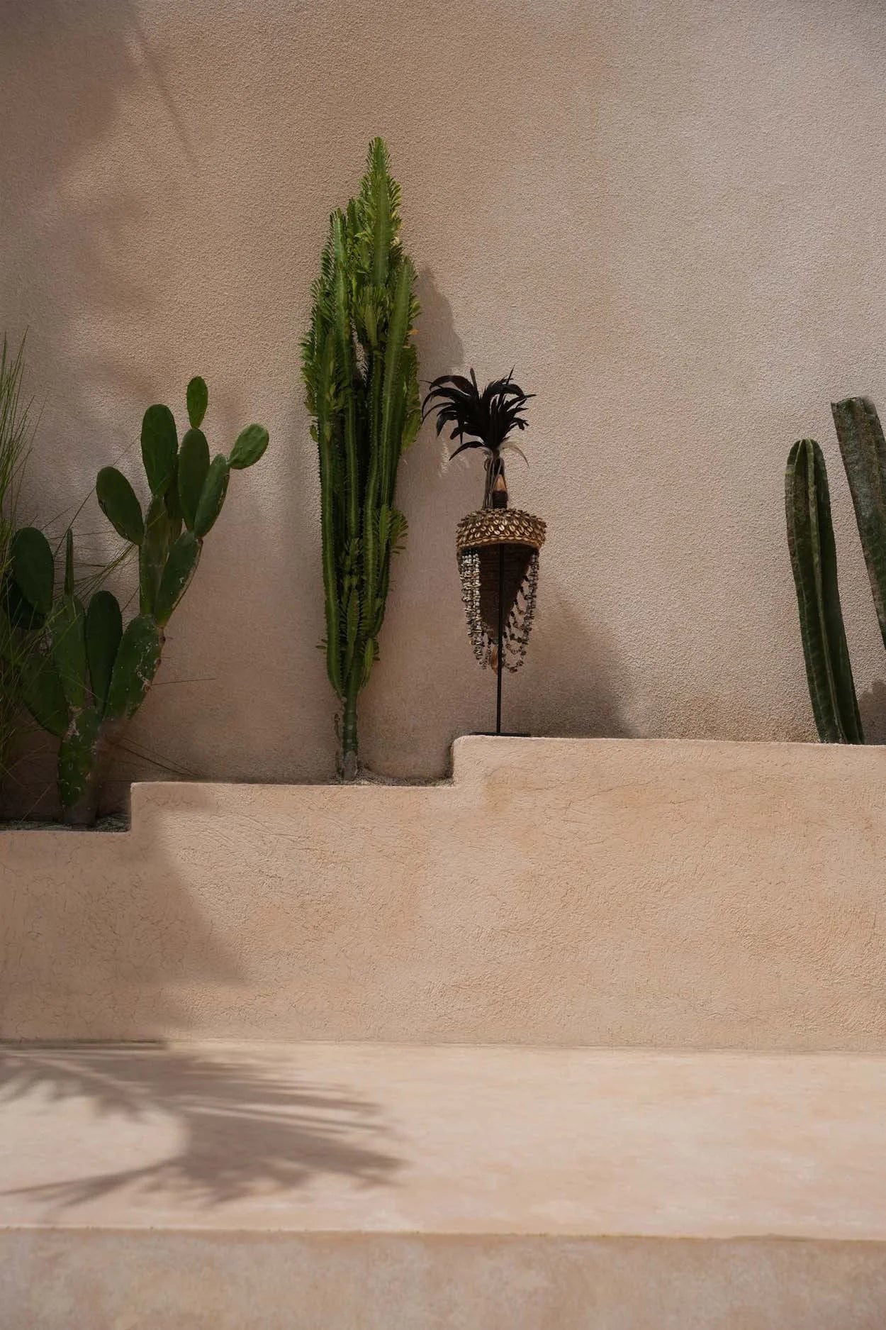 Coiffe tribale décorative en coquillages et plumes sur socle noir naturel