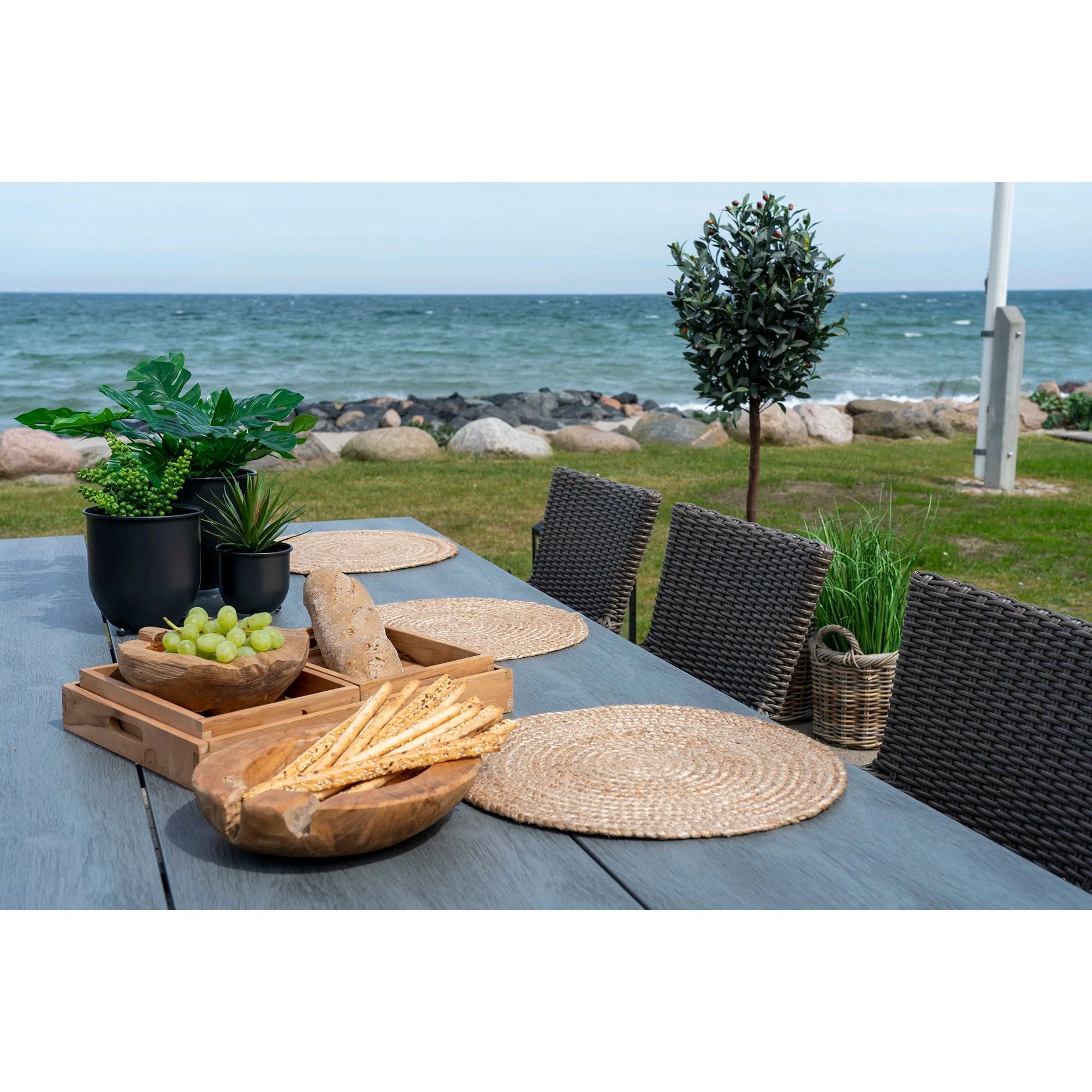 Décoration extérieure avec table en teck sculpté et vue sur la mer