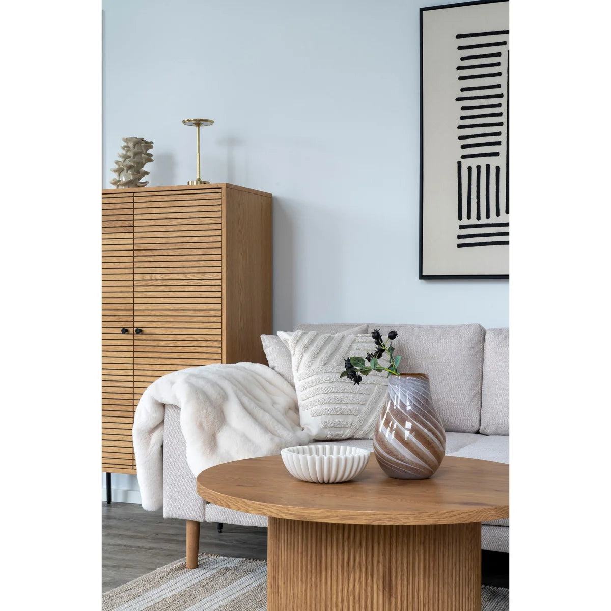 Vase en céramique beige cannelé mat, bord ondulé, sur table en bois