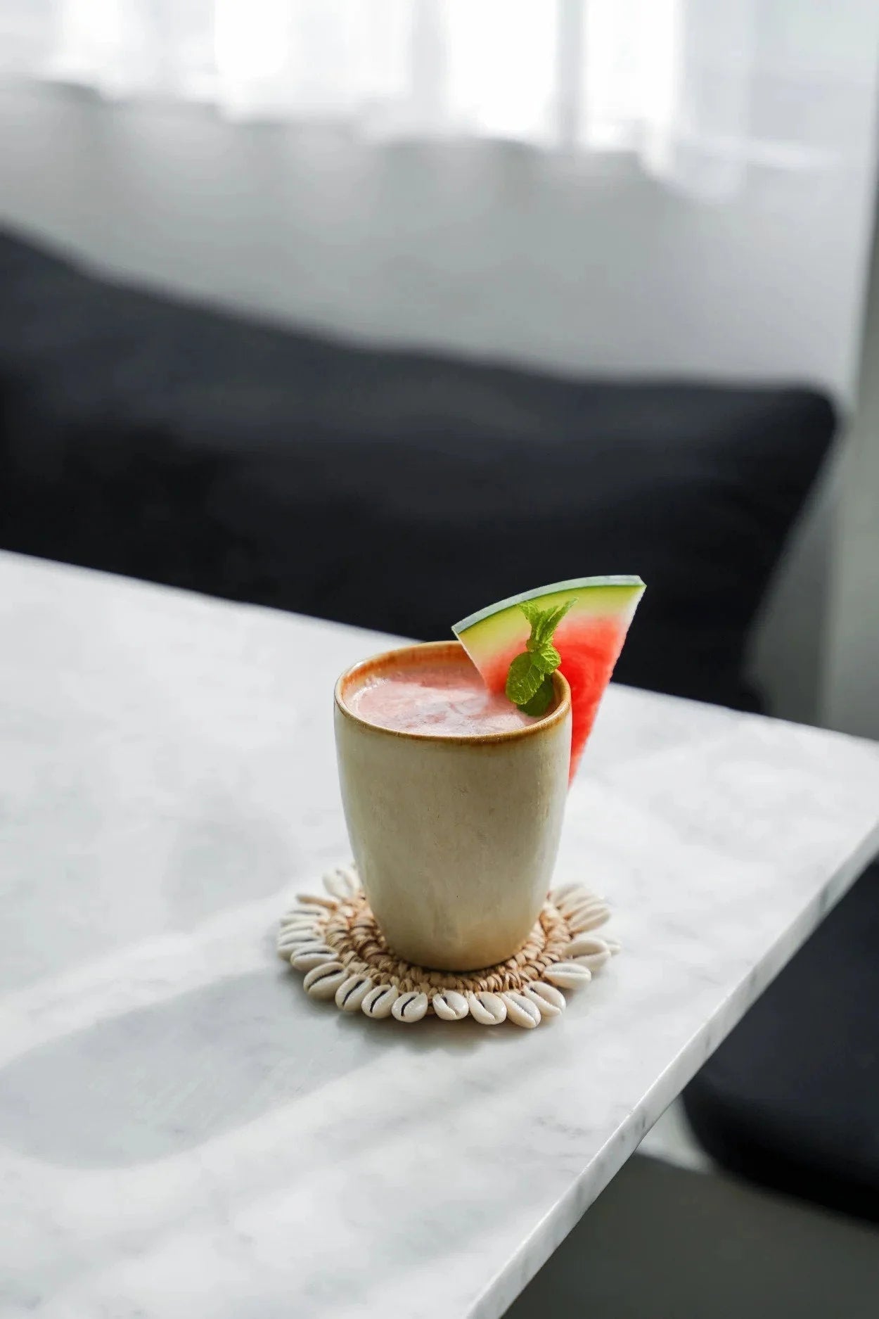 Coupe en céramique artisanale beige avec smoothie pastèque rose crémeux et garniture menthe