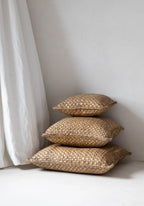 Coussins carrés en jacinthe tressée naturelle empilés pour décoration intérieure