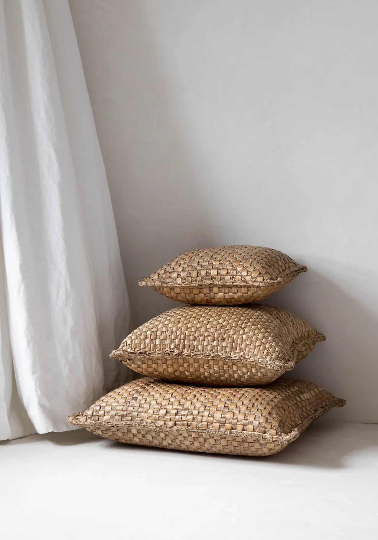 Coussins carrés en jacinthe tressée naturelle empilés pour décoration intérieure