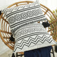 Coussin ethnique noir et blanc en situation sur une chaise