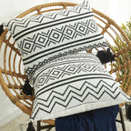 Coussin ethnique noir et blanc en situation sur une chaise