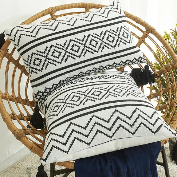 Coussin ethnique noir et blanc en situation sur une chaise