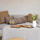 Coussin rectangulaire en velours gris sur un canapé, ambiance cosy