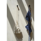 Maillot de bain deux pièces bleu marine suspendu sur un crochet mural en coquillages blancs