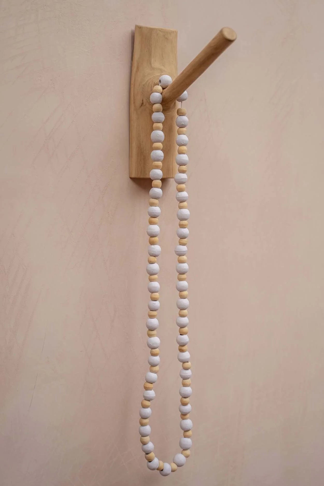 Crochet mural en teck naturel avec un crochet mural et un collier de perles blanches et marron