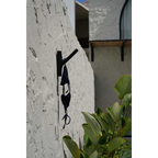 Bikini noir en crochet suspendu sur un crochet mural dans la pièce design Teck Noir