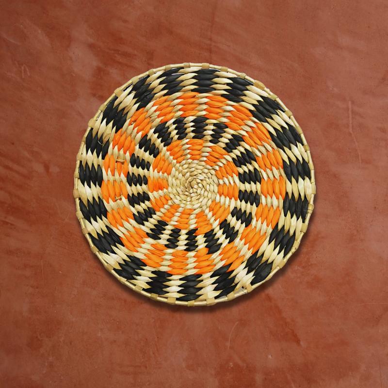 Déco murale en rotin orange noir sur un mur