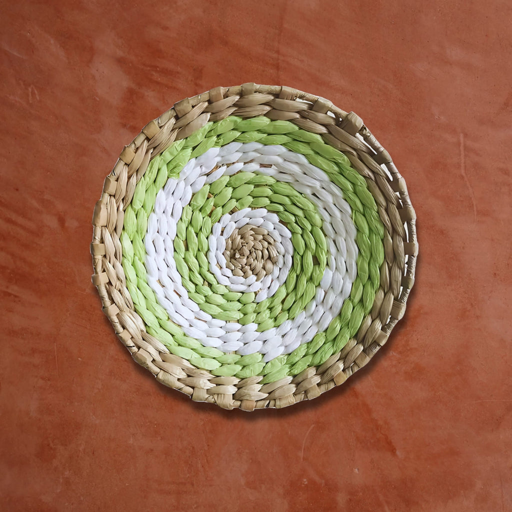 Déco murale en rotin rond vert blanc sur un mur