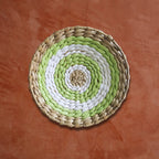 Déco murale en rotin rond vert blanc sur un mur