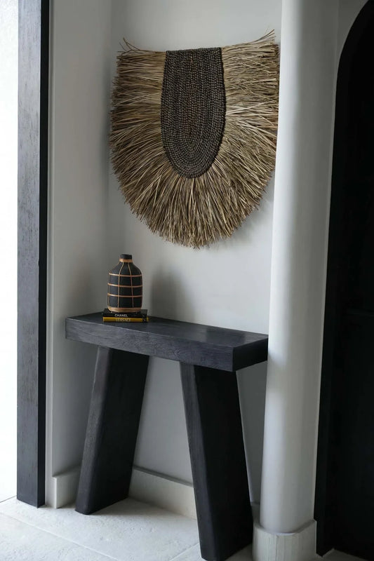 Table console sombre avec décoration murale ronde en herbe tressée naturelle 85 cm