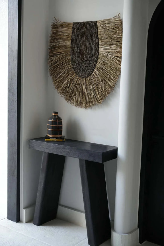 Table console sombre avec décoration murale ronde en herbe tressée naturelle 85 cm