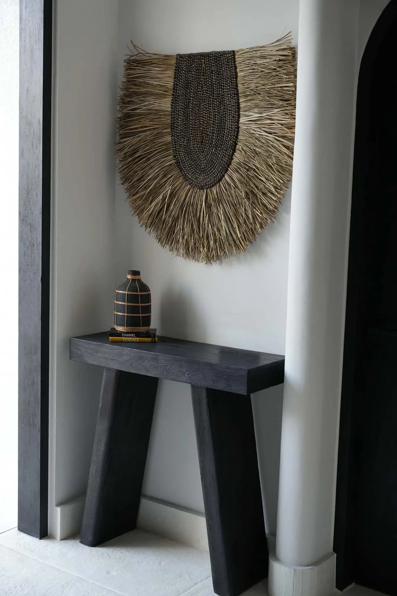 Table console sombre avec décoration murale ronde en herbe tressée naturelle 85 cm