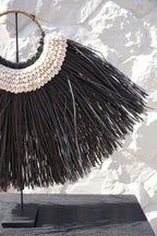 Décoration murale en raffia noir et blanc avec coquillages et herbe d’alang