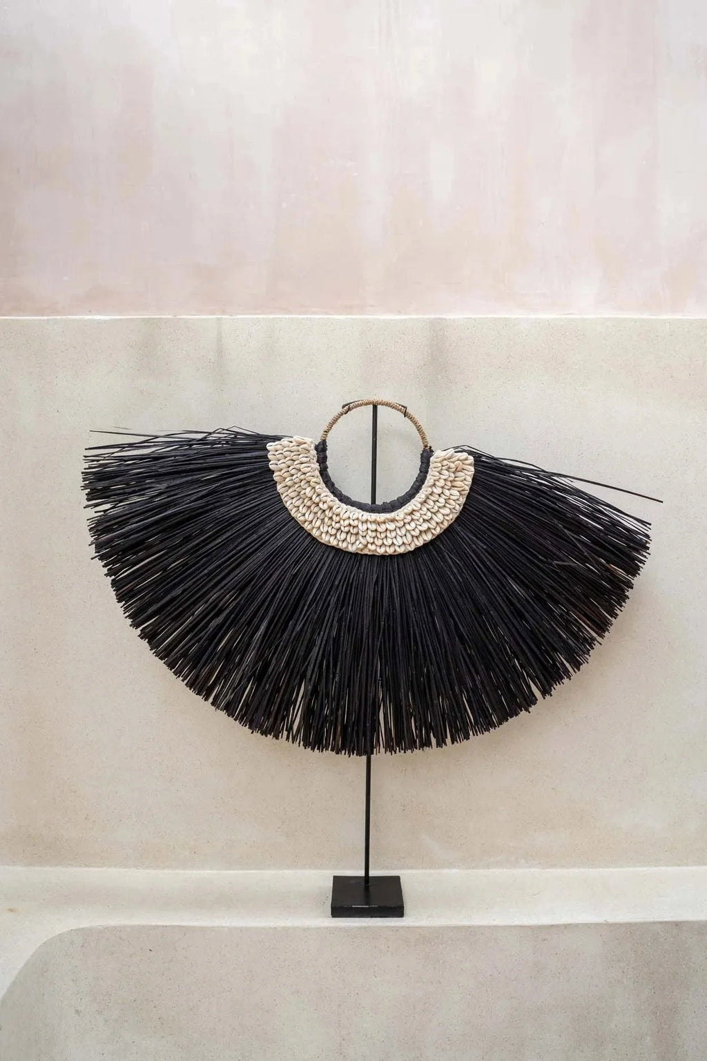 Décoration murale en raffia noir et coquillages sur pied en forme d’arc