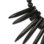 Collier en bois noir avec piques sur support décoration en herbe rayung et bois naturel