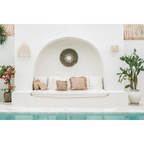 Lounge extérieur blanc avec coussins dans une alcôve en bord de piscine