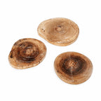 Trois sous-verres en bois en forme de tranches d’arbre.