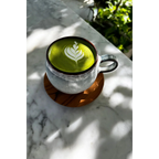 Matcha latte vert vif avec art latte blanc dans une tasse en céramique rustique