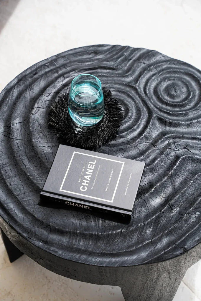 Table basse noire avec livre et verre, parfait pour Le dessous de verre en raphia à franges