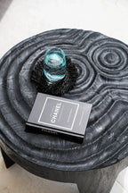 Table basse noire avec livre et verre, parfait pour Le dessous de verre en raphia à franges