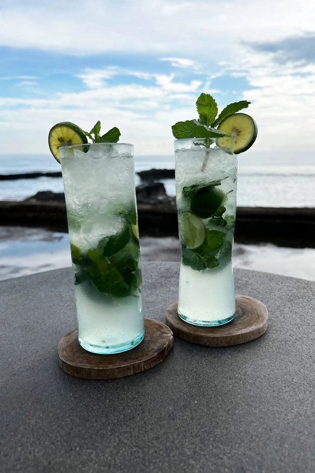 Dessous de verre rond en racine de teck avec mojitos rafraîchissants garnis de lime et menthe