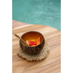 Verre en coque de noix de coco brun avec tranches d’orange et paille sur sous-verre rond en raphia naturel à franges solaires