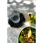 Saladier vert avec avocat, pois chiches rôtis et tranche de citron, dessous de verre rond en raphia noir avec franges