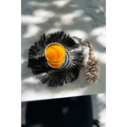 Verre de jus d’orange sur un dessous de verre rond en raphia noir avec franges